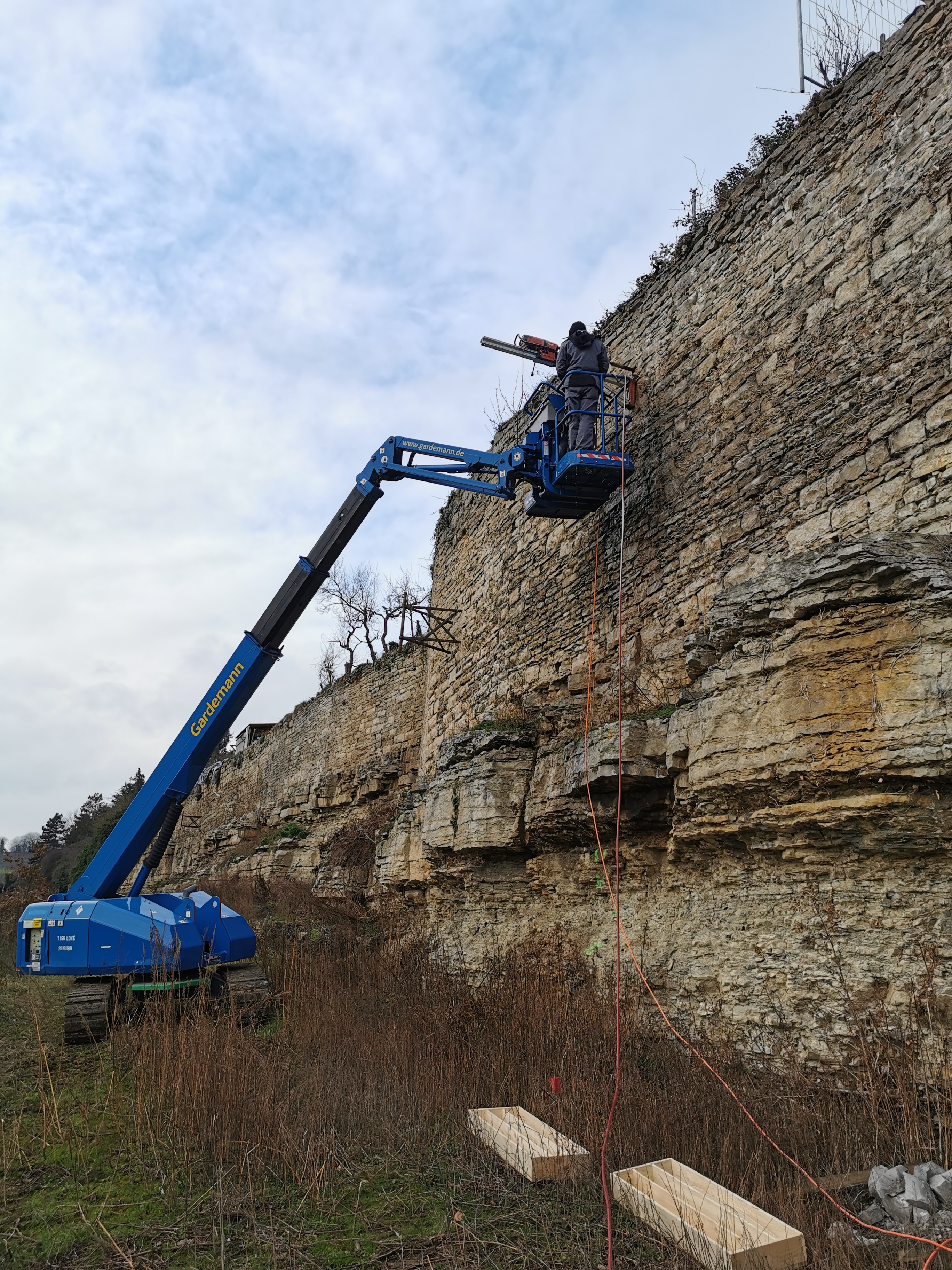 Kernbohrung in historische Natursteinmauer mit Teleskoplader